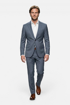 Pak 2-delig miniruit blauw-grijs model in een grijs pak met notch revers en bruin leren schoenen.